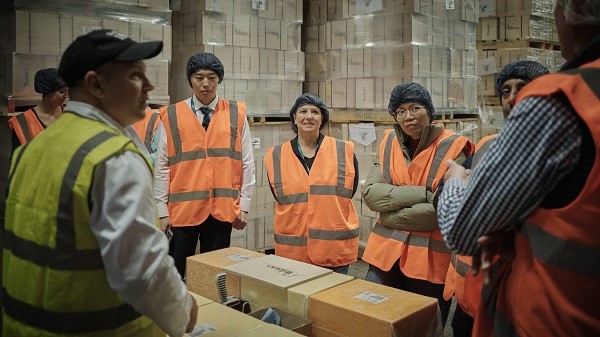 People standing in front of boxes wearing high vis vests.